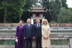 Le secrétaire général du Parti, Tô Lâm, et son épouse Ngo Phuong Ly, le président français, Emmanuel Macron, et son épouse Brigitte Macron, au Temple de la Littérature – Quoc Tu Giam. Photo: VNA