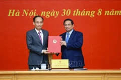 Le Premier ministre Pham Minh Chinh (droite) remet à Lê Hoai Trung la décision concernant sa nomination au poste de ministre par intérim des Affaires étrangères. Photo: VNA