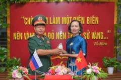 Le général Luu Trong Lu, président de l’Association des anciens combattants de la province de Diên Biên, remet l’urne contenant la terre sacrée à Vu Thi Tuyet Nga, directrice du Musée de la Victoire de Diên Biên Phu. Photo : VNA