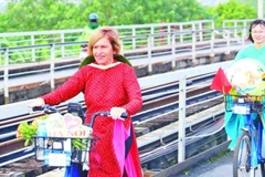 Stella Ciorra dans un périple à vélo pour promouvoir l'áo dài vietnamien. Photo : Journal Nhân Dân électronique