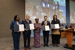 La directrice générale de l’OMC, Ngozi Okonjo-Iweala, avec des représentants de pays membres. Photo: VNA