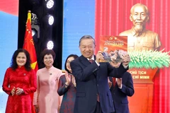 Le secrétaire général du Parti, To Lam, reçoit l’album photo « La gloire appartient à jamais au Peuple », offertpar l’Agence vietnamienne d’Information. Photo: VNA