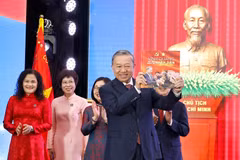 Le secrétaire général du Parti, To Lam, reçoit l’album photo « La gloire appartient à jamais au Peuple », offertpar l’Agence vietnamienne d’Information. Photo: VNA