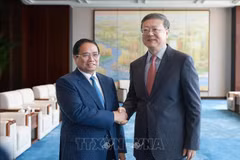 Le Premier ministre Pham Minh Chinh (gauche) et Chen Jining, membre du Bureau politique du Comité central du Parti communiste chinois (PCC) et secrétaire du Comité du PCC pour la ville de Shanghai. Photo: VNA