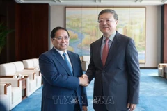 Le Premier ministre Pham Minh Chinh (gauche) et Chen Jining, membre du Bureau politique du Comité central du Parti communiste chinois (PCC) et secrétaire du Comité du PCC pour la ville de Shanghai. Photo: VNA