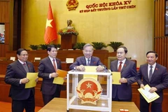 Le secrétaire général du Parti, To Lam, le président Luong Cuong, le Premier ministre Pham Minh Chinh, le président de l'Assemblée nationale Tran Thanh Man et des délégués votent lors de la séance. Photo: VNA