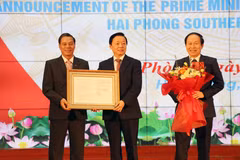Le vice-Premier ministre Tran Hong Ha (au milieu) remet la décision du Premier ministre sur la création de la zone économique côtière sud de Hai Phong. Photo : VNA