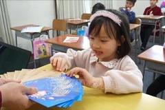 La petite Mai Chi, 5 ans, élève de l'école, est ravie de recevoir des étrennes du Nouvel An, selon la tradition du Têt vietnamien. Photo : VNA