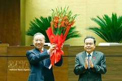 Le président de l’Assemblée nationale, Tran Thanh Man, offre des fleurs de félicitations au secrétaire général du Parti et président de l’État, To Lam, au nom des dirigeants du Parti, de l’État et des députés de la 16e législature. Photo : VNA