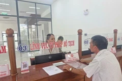 Un homme dépose ses demandes le jour de l'expérimentation du modèle d'administration locale à deux niveaux, dans le quartier de Pleiku, à Gia Lai. Photo : VNA