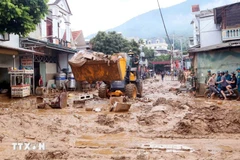Des excavatrices aident à ramasser la boue, les branches d'arbres et les déchets emportés par les récentes inondations dans la commune de Song Ma, province de Son La. Photo : VNA