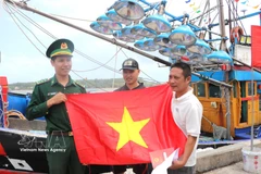 Remise de drapeaux nationaux à des pêcheurs. Photo : VNA