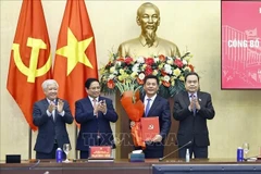 Le président de l’Assemblée nationale, Tran Thanh Man, a remis la décision, et le Premier ministre Pham Minh Chinh a offert des fleurs pour féliciter Nguyen Hong Dien. Photo: VNA
