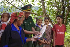 Un officier du poste de garde-frontière de Na Bung vulgarise des lois auprès des habitants locaux. Photo: VNA