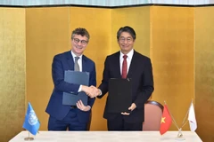 Le représentant en chef de l’UNESCO au Vietnam, Jonathan Wallace Baker (à gauche), et l'ambassadeur du Japon au Vietnam, Ito Naoki, lors de la cérémonie de signature. Photo: VNA