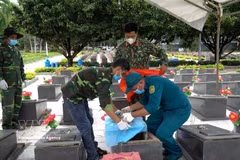 Prélèvement d'échantillons de restes de soldats au cimetière des martyrs de Duc Co. Photo: VNA