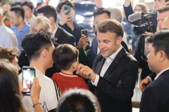 Le président français, Emmanuel Macron, et sa première dame rencontrent des habitants lors d'une promenade dans le Vieux Quartier de Hanoï, le soir du 26 mai. Photo: VNA