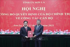 Lê Minh Hung, membre du Bureau politique et chef de la Commission d’organisation du Comité central du Parti (droite) remet la décision au noveau secrétaire du Comité du Parti de la province de Son La, Hoàng Van Nghiêm. Photo: VNA