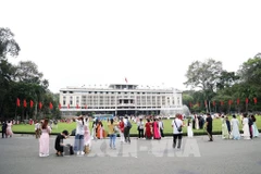 Visiteurs devant le Palais de la Réunification à Hô Chi Minh-Ville. Photo: VNA