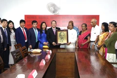 Le vice-président de l’Assemblée nationale, Nguyen Duc Hai (7e de gauche) offre un cadeau au Parti communiste du Sri Lanka. Photo: VNA