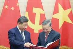 Le secrétaire général du Parti communiste du Vietnam To Lam offre le livre de photo de l'Agence vietnamienne d'Information au secrétaire général du PCC et président chinois Xi Jinping. Photo : VNA