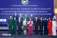 Des responsables vietnamiens et lao au banquet en l'honneur du 50ᵉ anniversaire de la Fête nationale du Laos. Photo: VNA