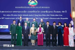 Des responsables vietnamiens et lao au banquet en l'honneur du 50ᵉ anniversaire de la Fête nationale du Laos. Photo: VNA