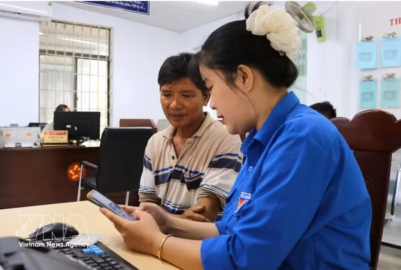 Une membre de l'anntenne de l'Union de la jeunesse communiste Ho Chi Minh à Dak Lak, aide un haibitant local à effectuer une démarche administrative en ligne. Photo: VNA