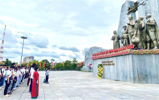 La délégation de jeunes Vietnamiens d’outre-mer devant le monument dédié au Président Hô Chi Minh et aux populations de Quang Binh. Photo: VNA