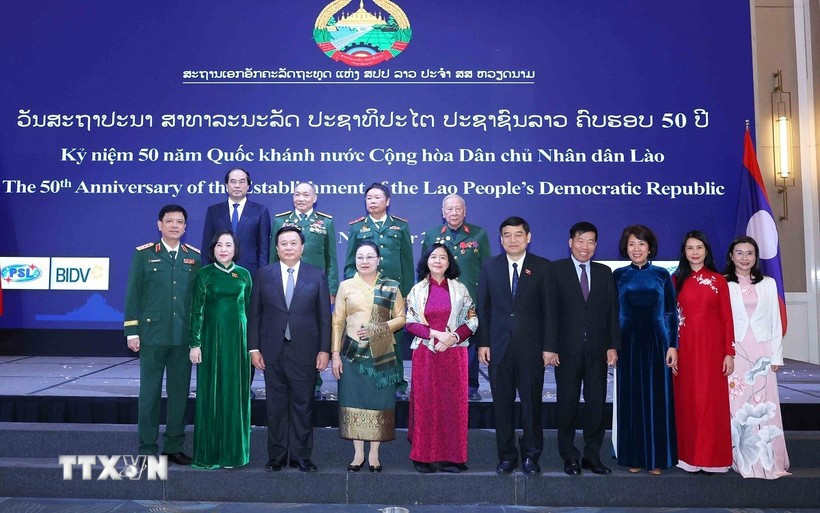 Des responsables vietnamiens et lao au banquet en l'honneur du 50ᵉ anniversaire de la Fête nationale du Laos. Photo: VNA