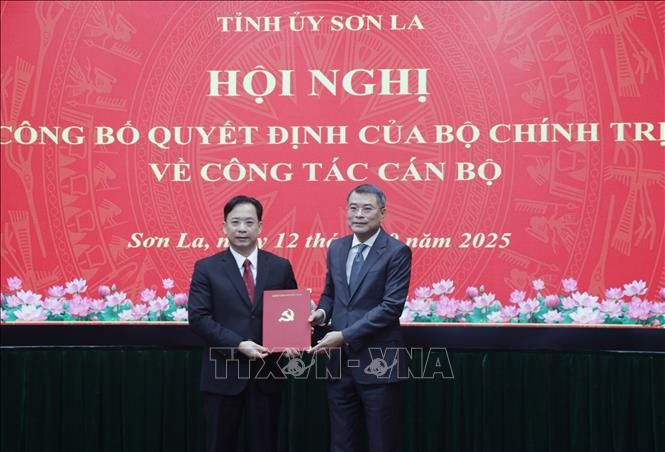 Lê Minh Hung, membre du Bureau politique et chef de la Commission d’organisation du Comité central du Parti (droite) remet la décision au noveau secrétaire du Comité du Parti de la province de Son La, Hoàng Van Nghiêm. Photo: VNA