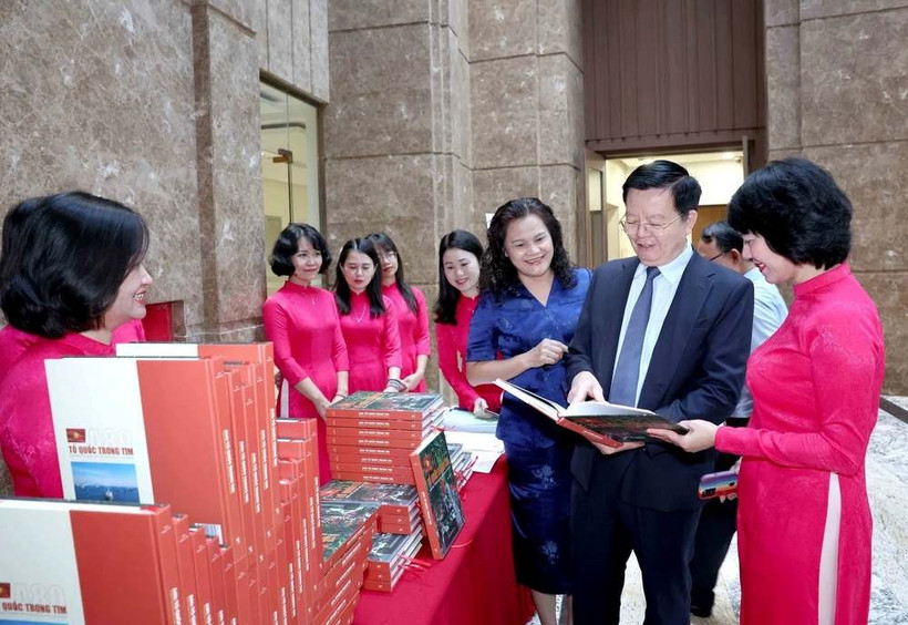 Le vice-Premier ministre Mai Van Chinh apprécie le livre photo « A80 : la Patrie dans le cœur ». Photo: VNA