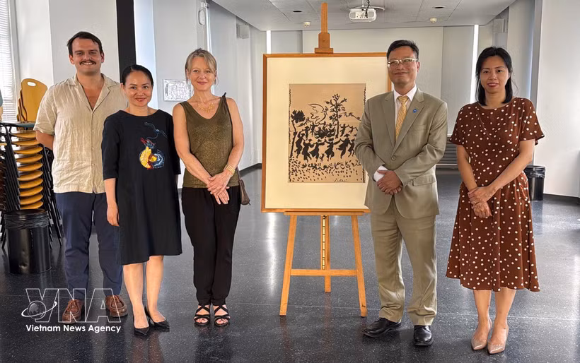 L’ambassadeur vietnamien Trinh Duc Hai (2e de droite) et la directrice du Musée d’Art et d’Histoire Paul Éluard, Valérie Perlès (3e de droite) à côté de l’œuvre originale "Vive la Paix", réalisée par le peintre Pablo Picasso. Photo: VNA