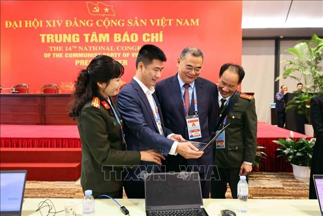 Des reporters travaillent au Centre de presse du 14e Congrès national du Parti. Photo: VNA