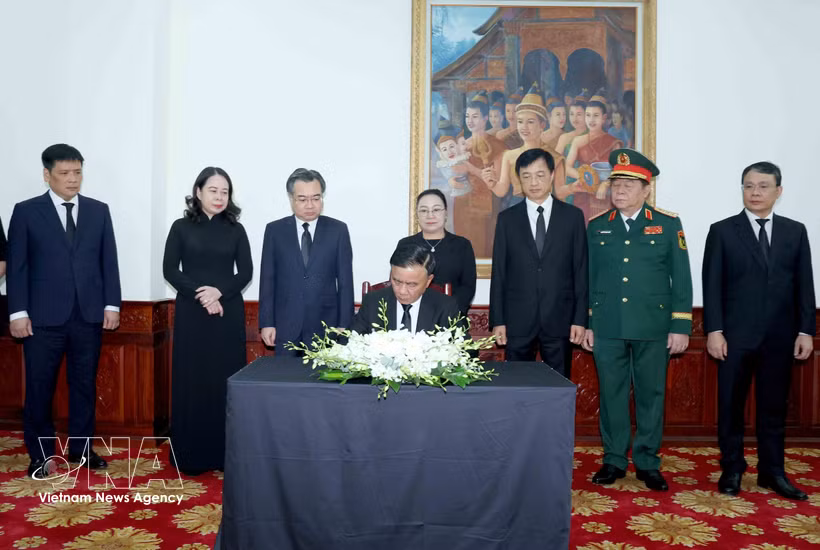 Tran Cam Tu, membre du Bureau politique et permanent du Secrétariat du Comité central du Parti écrit dans le registre de condoléances. Photo: VNA