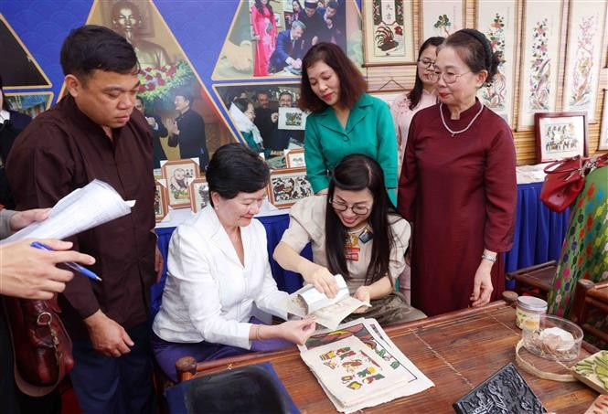 L'épouse du Premier ministre Pham Minh Chinh, Lê Thi Bich Trân et des membres de l'AWCH assistent à la fabrication de peintures folkloriques Dông Hô. Photo: VNA