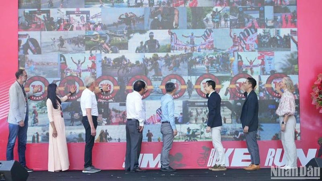 Les organisateurs appuient sur le bouton pour inaugurer l'événement sportif Ironman 70.3 Da Nang 2025. Photo : https://nhandan.vn lancement.jpg