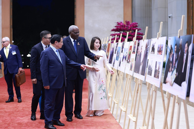 Le Premier ministre Pham Minh Chinh et le président de l'Assemblée nationale de Cuba Esteban Lazo Hernández visitent une exposition de photos sur la coopération entre les deux pays. Photo: VNA expo.jpg