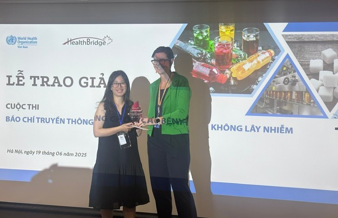 La Dr Angela Pratt, représentante en chef de l'OMS au Vietnam, remet le premier prix à la journaliste Vu Thi Nam Phuong du journal électronique "Dan tri". Photo : VietnamPlus 2.jpg