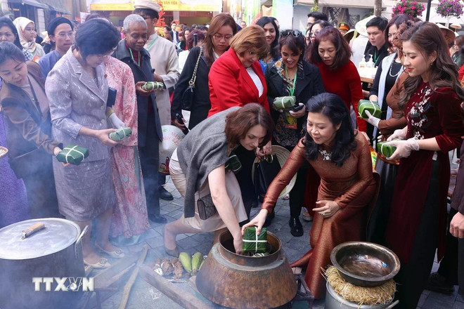 Les délégués ont mis la main à la pâte en préparant eux-mêmes des bánh chưng, de l'enveloppement à la cuisson. Photo: VNA 1601-phu-nhan-tong-bi-thu-5.jpg