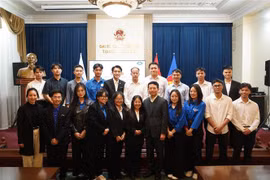 Le ministre de l'Information et de la Communication, Nguyen Manh Hung, et les étudiants vietnamiens lors de la rencontre. Photo: VNA