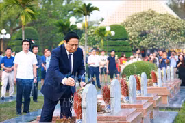 Le Premier ministre Pham Minh Chinh allume de l'encens sur des tombes au Cimetière national des martyrs A1. Photo: VNA