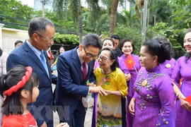 Le vice-Premier ministre Vu Duc Dam rencontre des Vietnamiens en Thaïlande