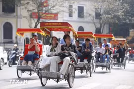 Les touristes expérimentent le voyage en cyclo autour du lac Hoan Kiem. Photo: VNA