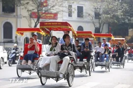 Les touristes expérimentent le voyage en cyclo autour du lac Hoan Kiem. Photo: VNA