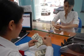 Le taux de change devrait réduire la fin de l'année, selon les experts de l'UOB. Photo: Vietnamplus