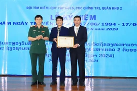 Des représentants du ministère vietnamien de la Défense et d'Oudomxay remettent un satisfecit à l'équipe l'équipe de recherche et de collecte des restes des soldats tombés de la région militaire 2, au Laos. Photo: VNA