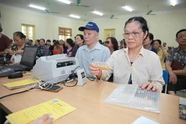 Paiement de la pension pour des personnes âgées. Photo: Vietnamplus