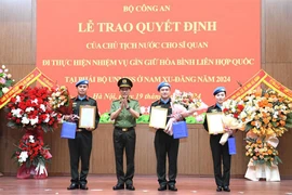 Le ministre de la Sécurité Publique, Luong Tam Quang, remet la décision du président à trois officiers. Photo: bocongan.gov.vn