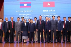 L'inspecteur général du gouvernement vietnamien Doan Hong Phong et son homologue lao Khamphan Phommaphat prennent une photo avec les inspecteurs de deux pays. Photo: VNA